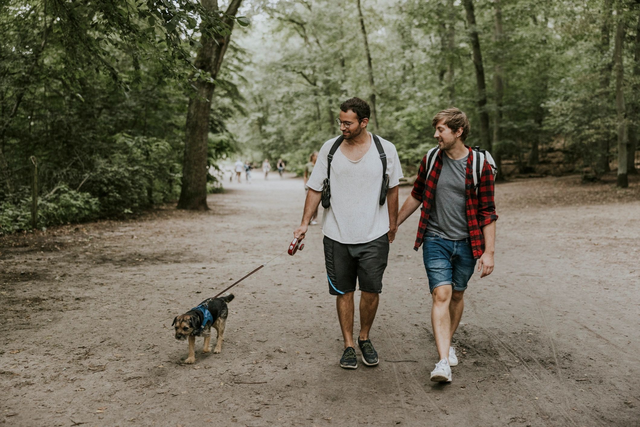 Pet owners walking with their dog in a public park